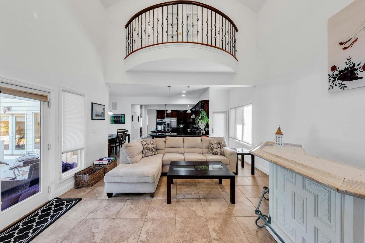 Living area featuring a towering ceiling and light tile patterned flooring