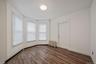 Unfurnished room featuring dark wood-style flooring and radiator