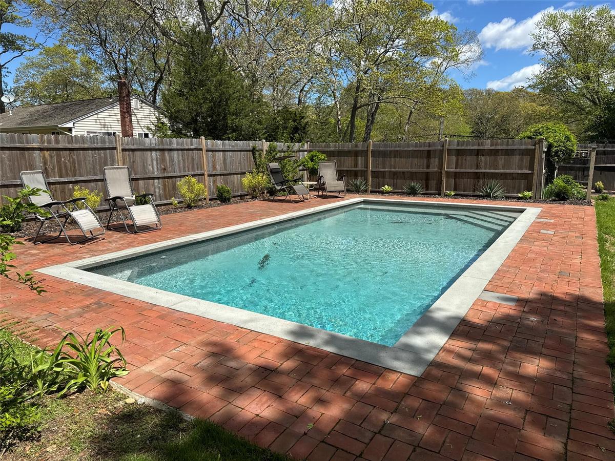 View of swimming pool with a patio area and a fenced backyard