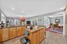 Kitchen featuring recessed lighting, brown cabinets, a baseboard heating unit, stone tile flooring, and butcher block countertops