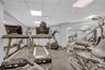 Exercise room featuring a drop ceiling, an AC wall unit, and visible vents