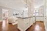 Gourmet kitchen with white shaker cabinetry, stainless steel appliances, dark countertops, and wood-finish flooring