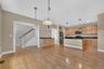 Hardwood floors, pendant lighting, and an open layout connect the kitchen beautifully with the rest of the main level.