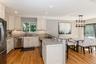Kitchen featuring stainless steel appliances, light stone countertops, light wood finished floors, recessed lighting, and a kitchen breakfast bar
