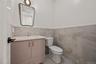 Bathroom with vanity, tile walls, light tile patterned floors, and a wainscoted wall