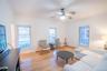 Living area featuring a baseboard heating unit, ornamental molding, wood finished floors, and baseboards