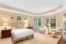 Bedroom featuring crown molding, a raised ceiling, access to exterior, and light carpet