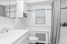 Bathroom featuring white tiled walls, a white vanity with integrated sink, and a chrome faucet