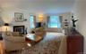 View of the formal living room with bay window and wood burning fireplace