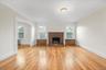 Living room with hardwood flooring, wood baseboard moldings, new windows, steam heating, cast iron radiators