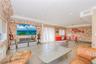 Living area featuring brick wall, wood-type flooring, and recessed lighting
