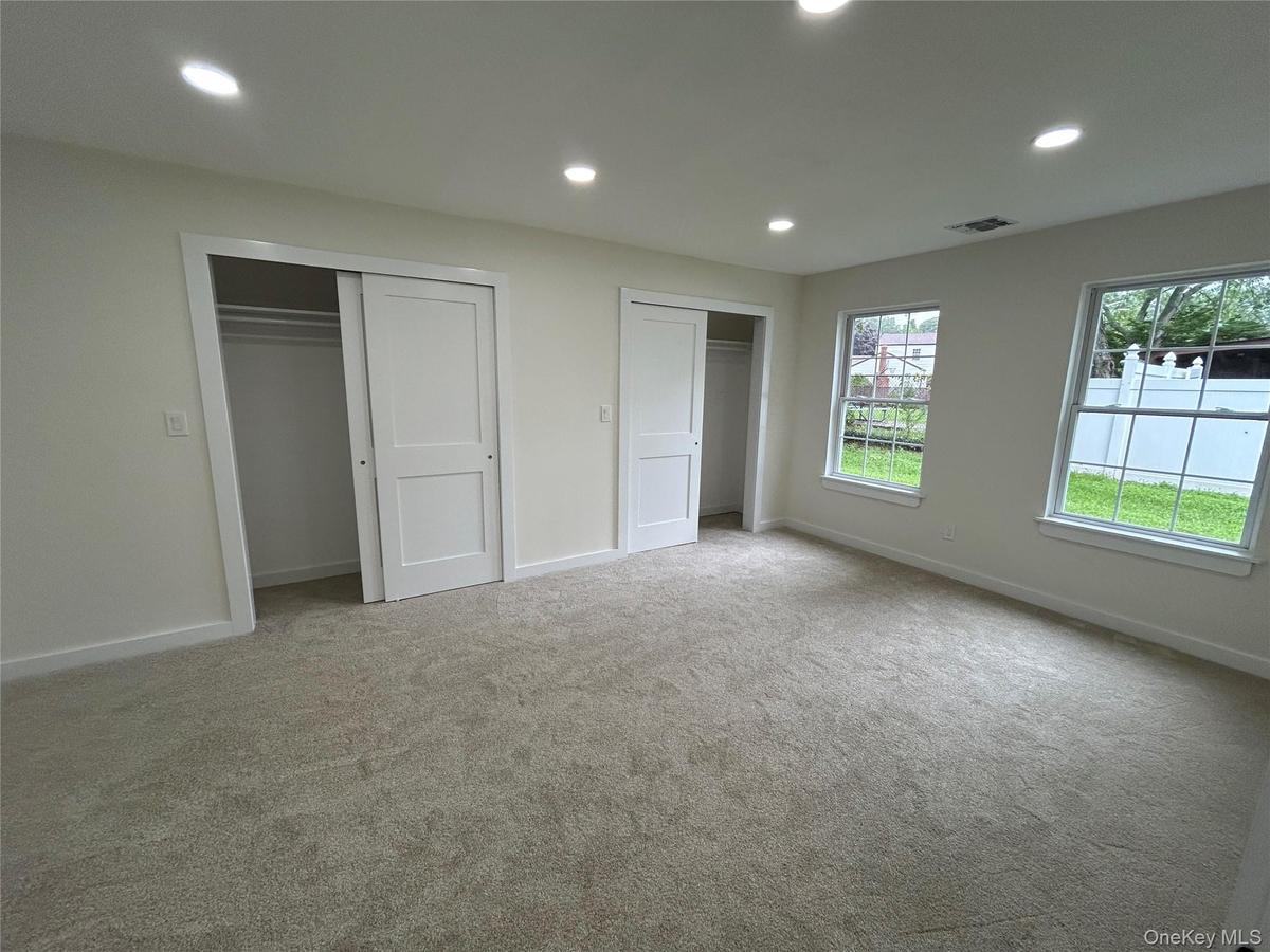 Bedroom with double closet and new carpeting