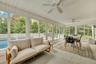 Sunroom / solarium featuring outdoor dining space, an outdoor hangout area, view of scattered trees, and a ceiling fan