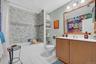 Full bathroom featuring shower / bath combo with shower curtain, light tile patterned floors, and vanity