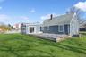 Back of property with a deck, a chimney, and a shingled roof