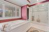 Spacious bathroom featuring a built-in jetted tub with a marble-finish surround, large windows, an expansive glass-enclosed shower with multiple showe