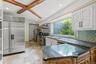 Kitchen with premium appliances, decorative backsplash, dark stone countertops, recessed lighting, and white cabinets