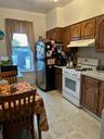 Kitchen featuring stove, light countertops, extractor fan, and freestanding refrigerator