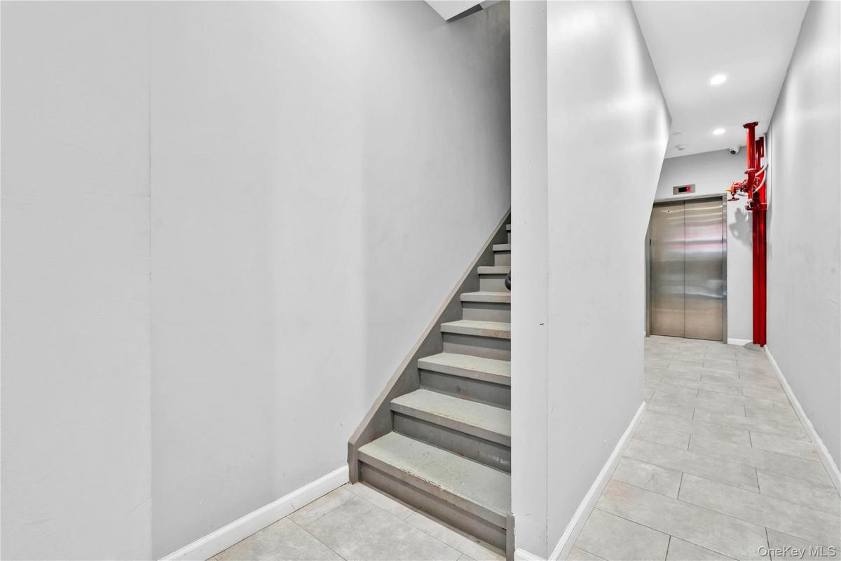 Stairs with elevator, tile patterned floors, and recessed lighting