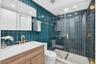 Upgraded bathroom w/ gorgeous finishes, rain shower head & handheld, tile to the ceiling, frameless shower door & medicine cabinet