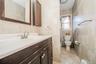 Bathroom featuring a dark wood vanity with an integrated white sink, brushed nickel faucet, and a coordinating framed mirror