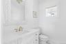 Half bathroom with vanity and marble look tile flooring