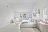 Bedroom featuring light wood-type flooring, a baseboard radiator, and high vaulted ceiling