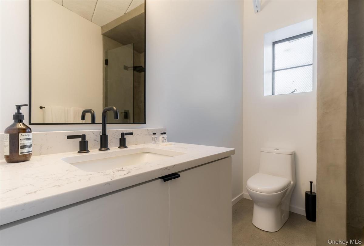 Full bathroom with vanity, an enclosed shower, and concrete floors