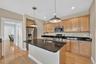 The kitchen offers generous workspace, warm wood cabinetry, granite countertops and easy flow into the adjoining living areas.