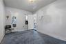 Unfurnished room featuring dark carpet and baseboards