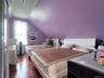 Room featuring sloped ceilings, purple wall finish, and wood-finish flooring