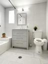 Full bath with tile walls, vanity, light tile patterned floors, and washtub / shower combination