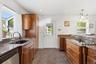 The heart of the home, offering abundant granite workspace, island seating, cherry cabinetry, a coffee station, stainless steel appliances, and storag