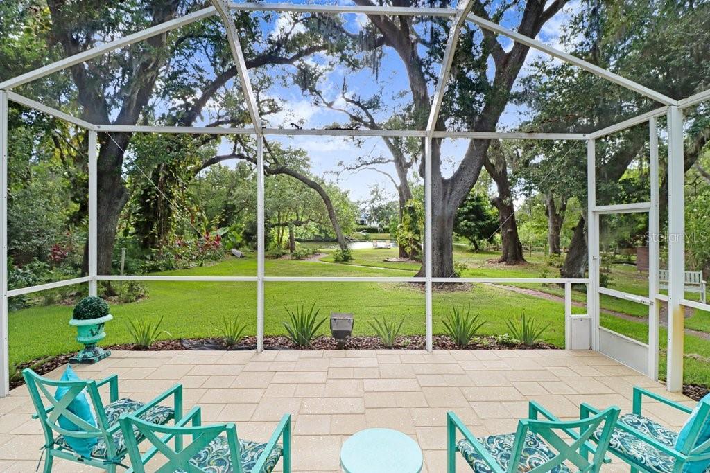 Serene private lakefront backyard with fruit trees, mature oaks, fire pit and floating dock.