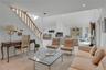 Open-concept living area with vaulted ceilings, recessed lighting, and a wood-finish staircase