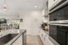 Well-appointed kitchen featuring built-in oven and microwave, solid surface countertops, abundant cabinetry, and a functional layout for everyday livi