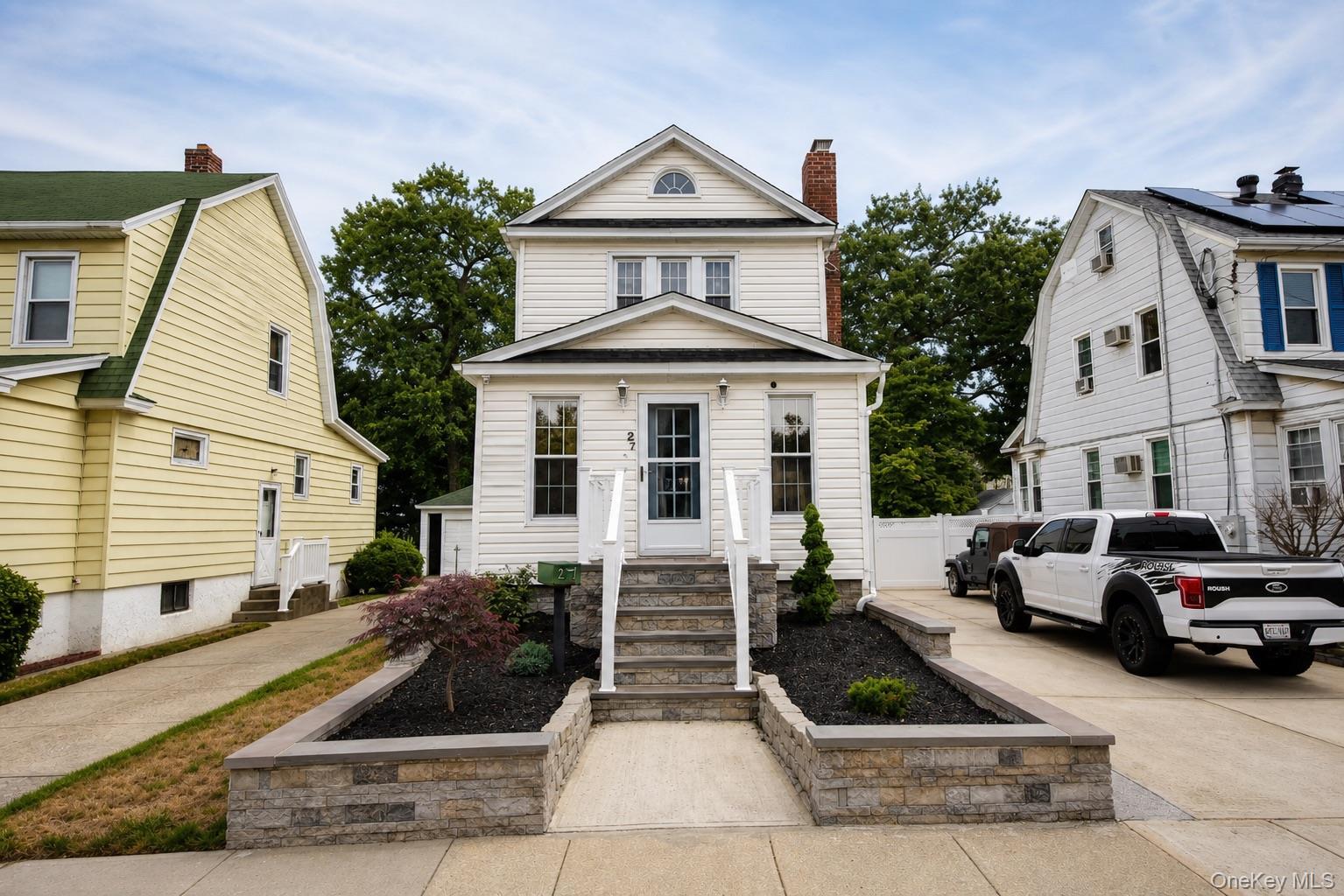 White siding exterior featuring a gabled roofline