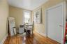 Sloped ceiling room featuring wood-finish flooring, a double window, and a flush-mount light fixture