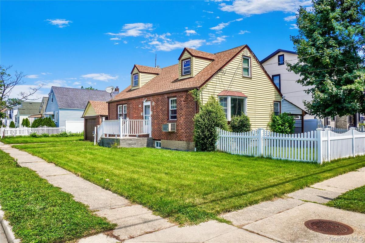 Traditional dormer-style home featuring brick and siding exterior