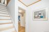 Stairs with crown molding and wood finished floors