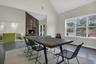 Dining area featuring a large fireplace, high vaulted ceiling, wood finished floors, and baseboards