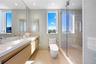 Bathroom featuring tile walls, vanity, a shower stall, and dark aggregate flooring