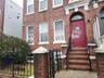 View of exterior entry featuring brick siding and a gate