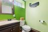 Bathroom vanity featuring a granite-style countertop, undermount sink, dark wood-finish cabinetry, and framed mirror