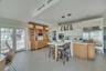 Kitchen with a kitchen bar, glass insert cabinets, decorative backsplash, decorative light fixtures, and built in appliances