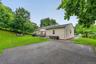 Private backyard features a spacious paved area offering plenty of flexibility for a basketball court, recreation area, or other outdoor activities.
