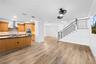 Entertainment area with view of kitchen and stairs