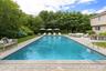 Swimming pool featuring a patio area, an outdoor living space, and view of scattered trees