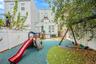 View of playground with a fenced backyard and a patio