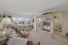 Living Room features windows with plantation shutters across the back as well as access to the patio through a sliding door.